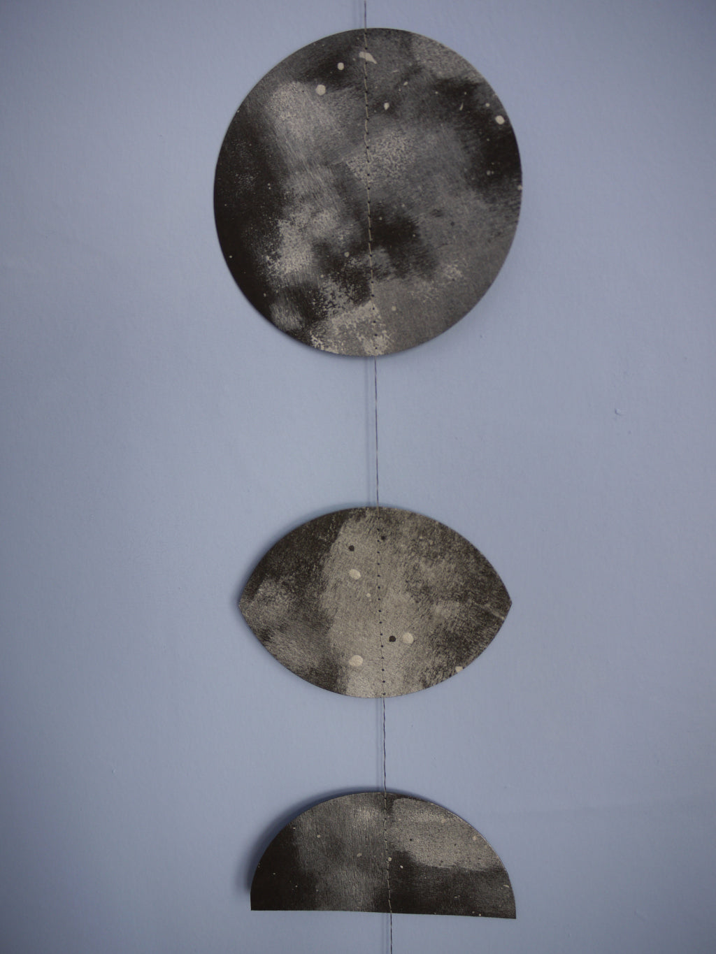 Decorative moon phases wall art. Close up on handpainted details of this decorative paper garland. Witchy decor as home wall art