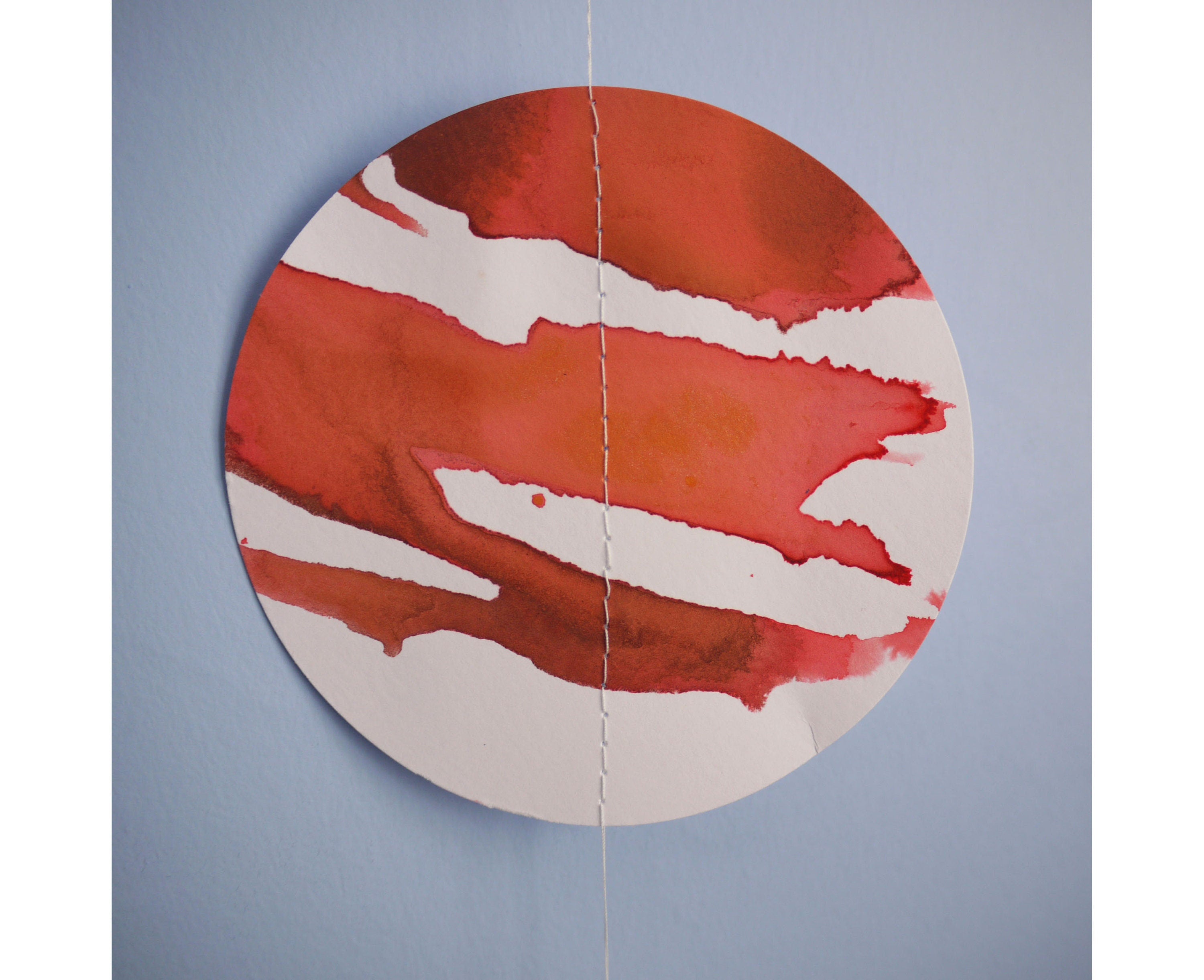 Red and white circle stitched through as part of a moon phases garland