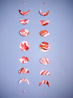 Two moon phases paper garlands in red and white showing the unique characteristics of each handmade item