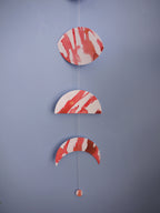 Red and white moon phases shapes as a stitched garland on a blue background