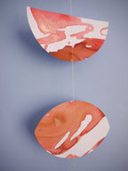 Moon shapes of a red and white stitched garland on a blue background