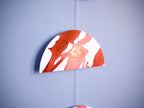Half moon shape from a red and white paper garland on a blue background