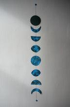 Decorative hanging with blue moon phases on a plain background. Nature inspired original designs