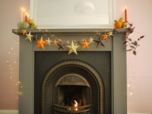 Decorative fireplace with star-shaped ornaments and candles on a mantel.