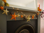 Decorative star garland with lights on a fireplace mantel.