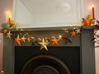 Decorative fireplace mantel with star-shaped ornaments and string lights.