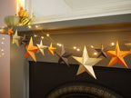 Decorative star garland with lights on a fireplace mantel.
