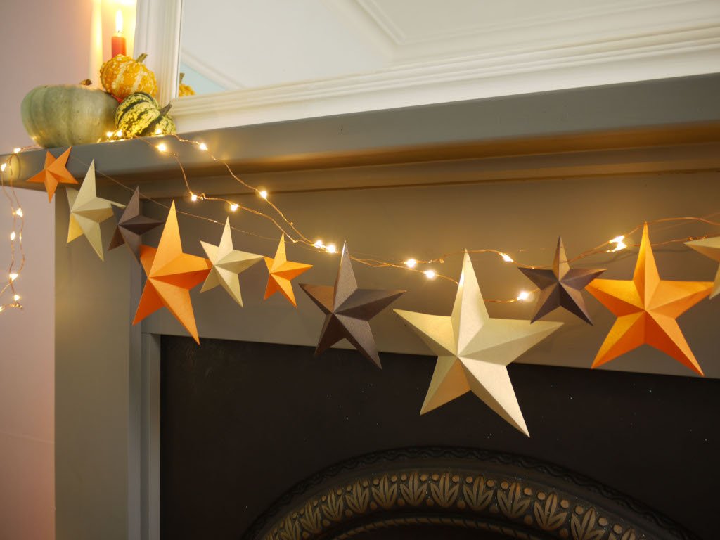 Decorative star garland with lights on a fireplace mantel.