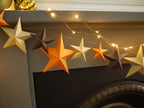 Decorative string lights with star-shaped decorations on a mantelpiece.