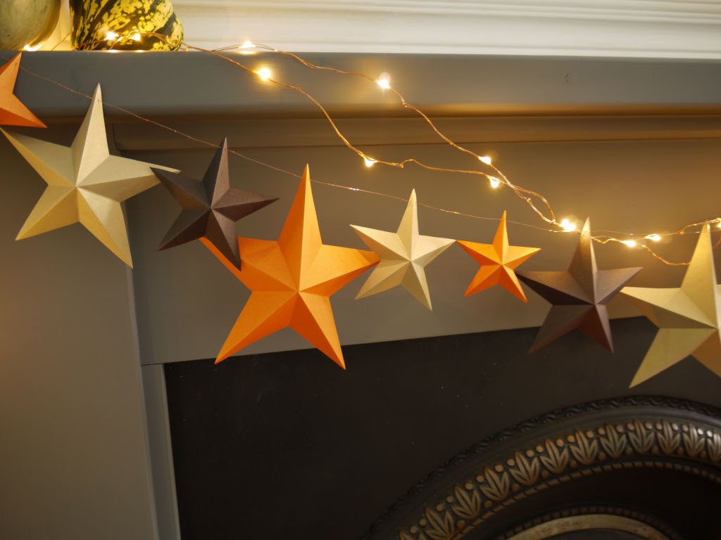 Decorative string lights with star-shaped decorations on a mantelpiece.