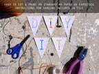 DIY banner with colorful letters, scissors, and pliers on a textured surface.