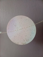 Close up on a circle of watercolour painted paper garland in soft pastel tones