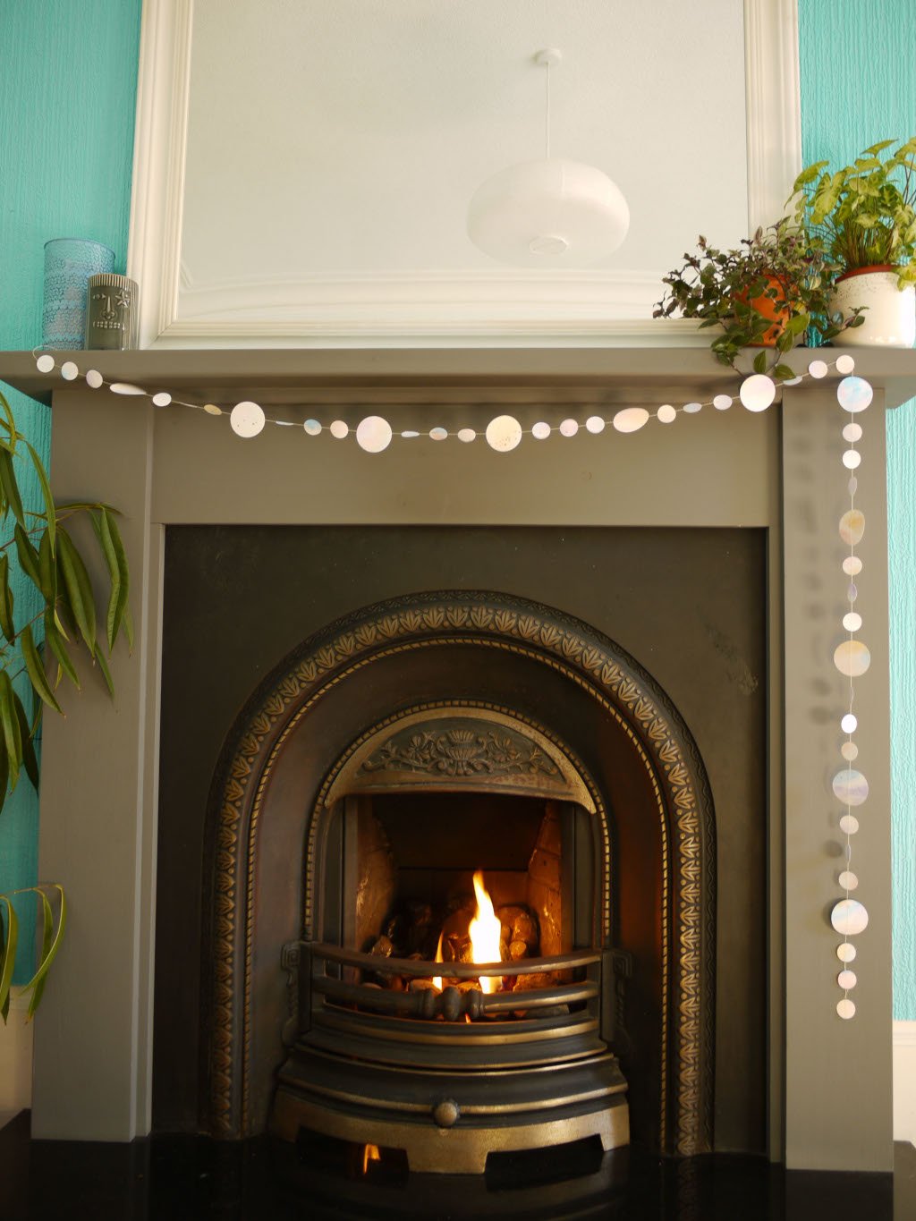 Watercolour painted paper garland in soft pastel tones at a fireplace