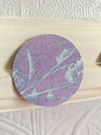 A close-up of a riso print cyanotype circle stitched as part of a paper garland.