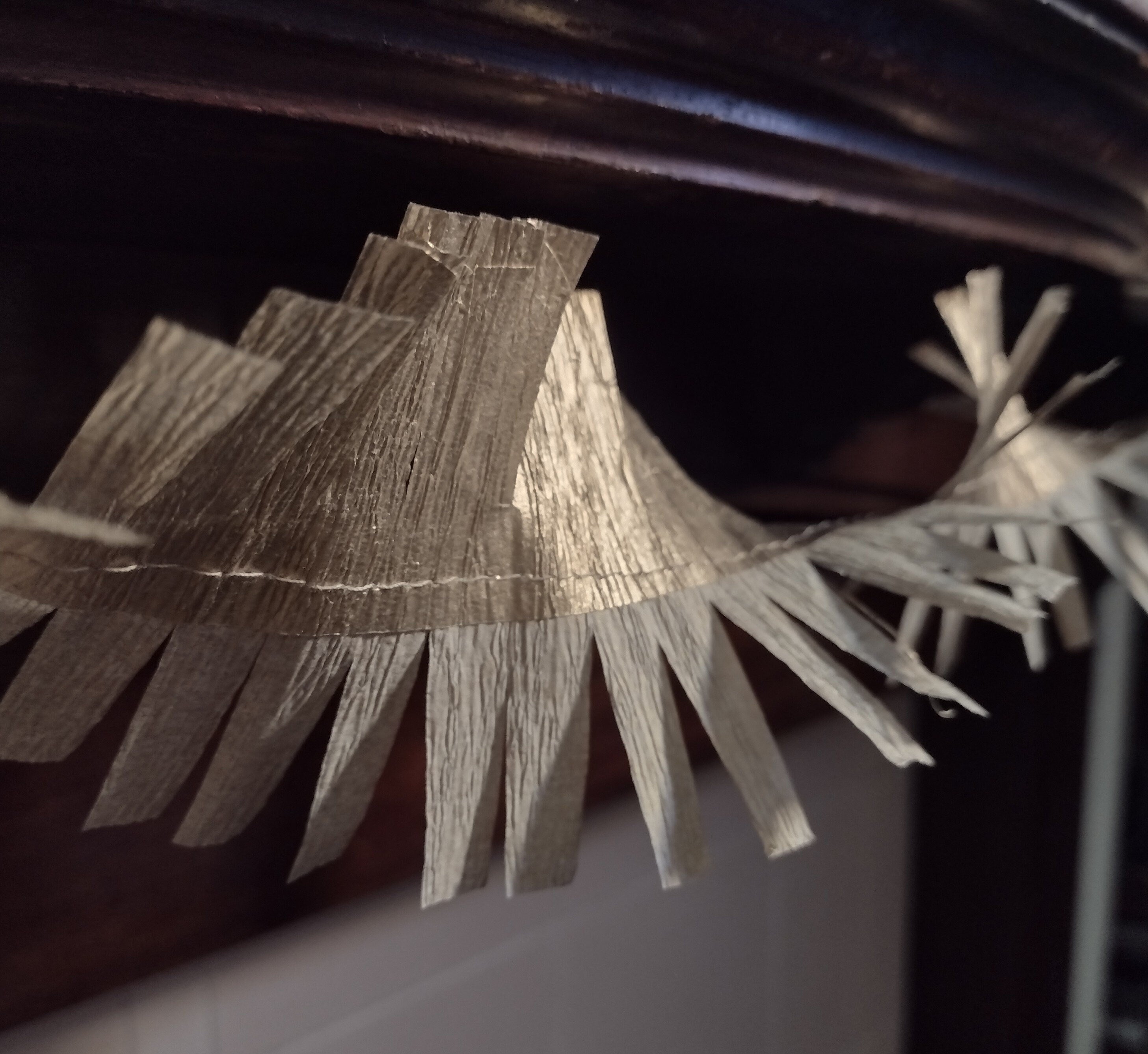 Close up on gold paper streamer at a mantelpiece