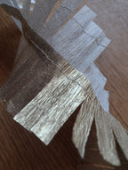 Close up on gold paper streamer on a wooden surface