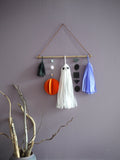 Halloween themed wall hanging with a ghost tassel, abstract pumpkin and black and purple decorations