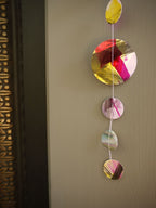  Close up on a painted paper garland in bold colours of pink, yellow, black, purple and holographic