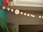 pink, yellow, orange and turquoise marbled paper garland on the mantelpiece