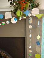 Close up of geometric and watercolour paper garlands in Paper Street Doll's OPHELIA colours of grey, grass green and blue