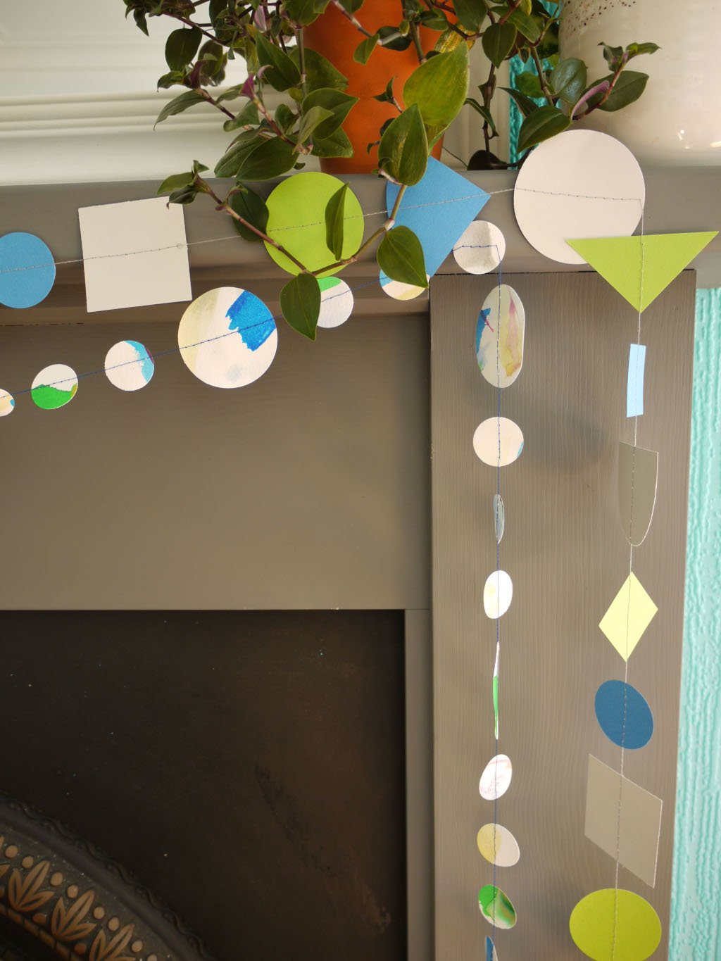 Close up of geometric and watercolour paper garlands in Paper Street Doll's OPHELIA colours of grey, grass green and blue