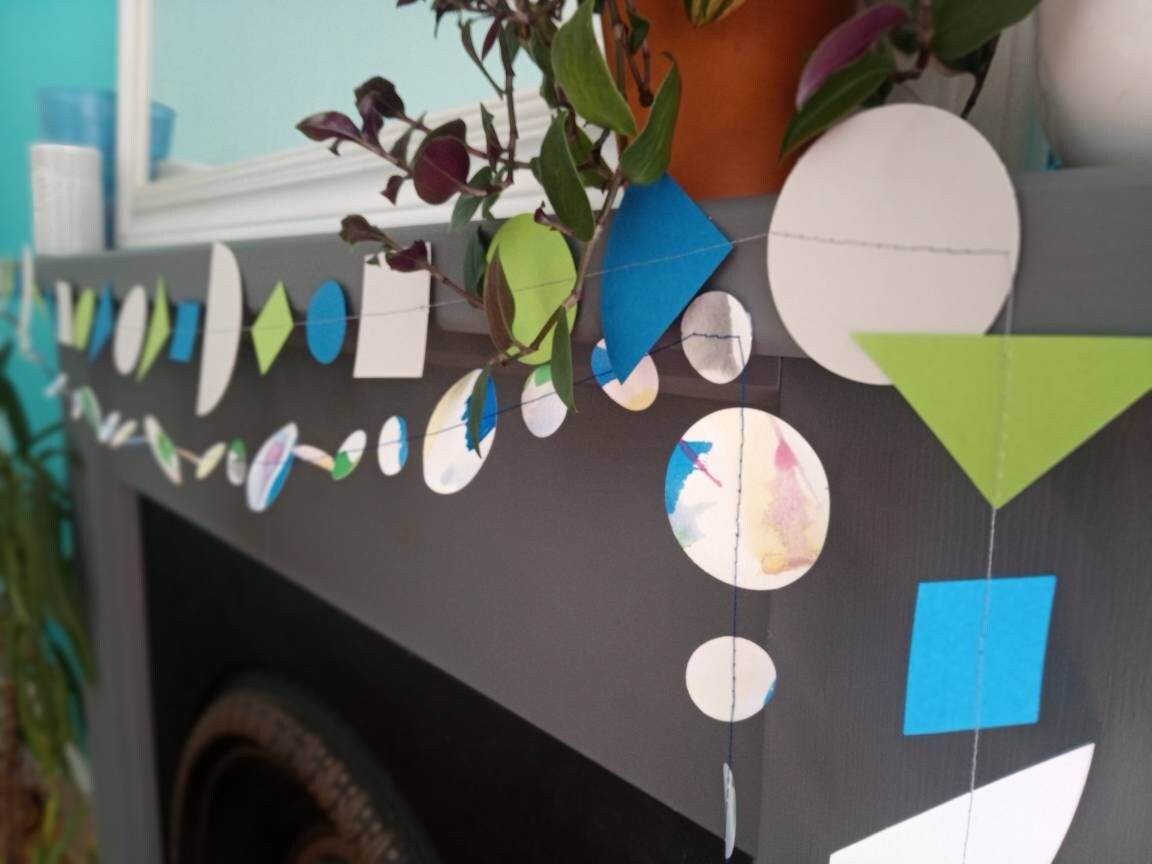 Geometric and watercolour paper garlands in Paper Street Doll's OPHELIA colours of grey, grass green and blue at a mantelpiece