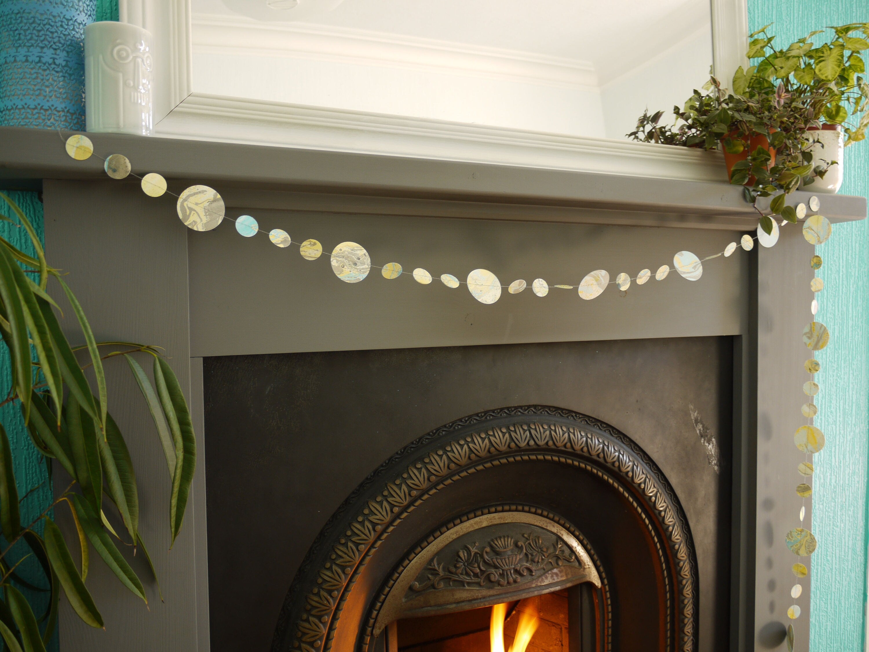 Yellow blue and greay marbled paper garland at a fireplace
