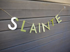 Green 'SLAINTE' banner on a grey surface