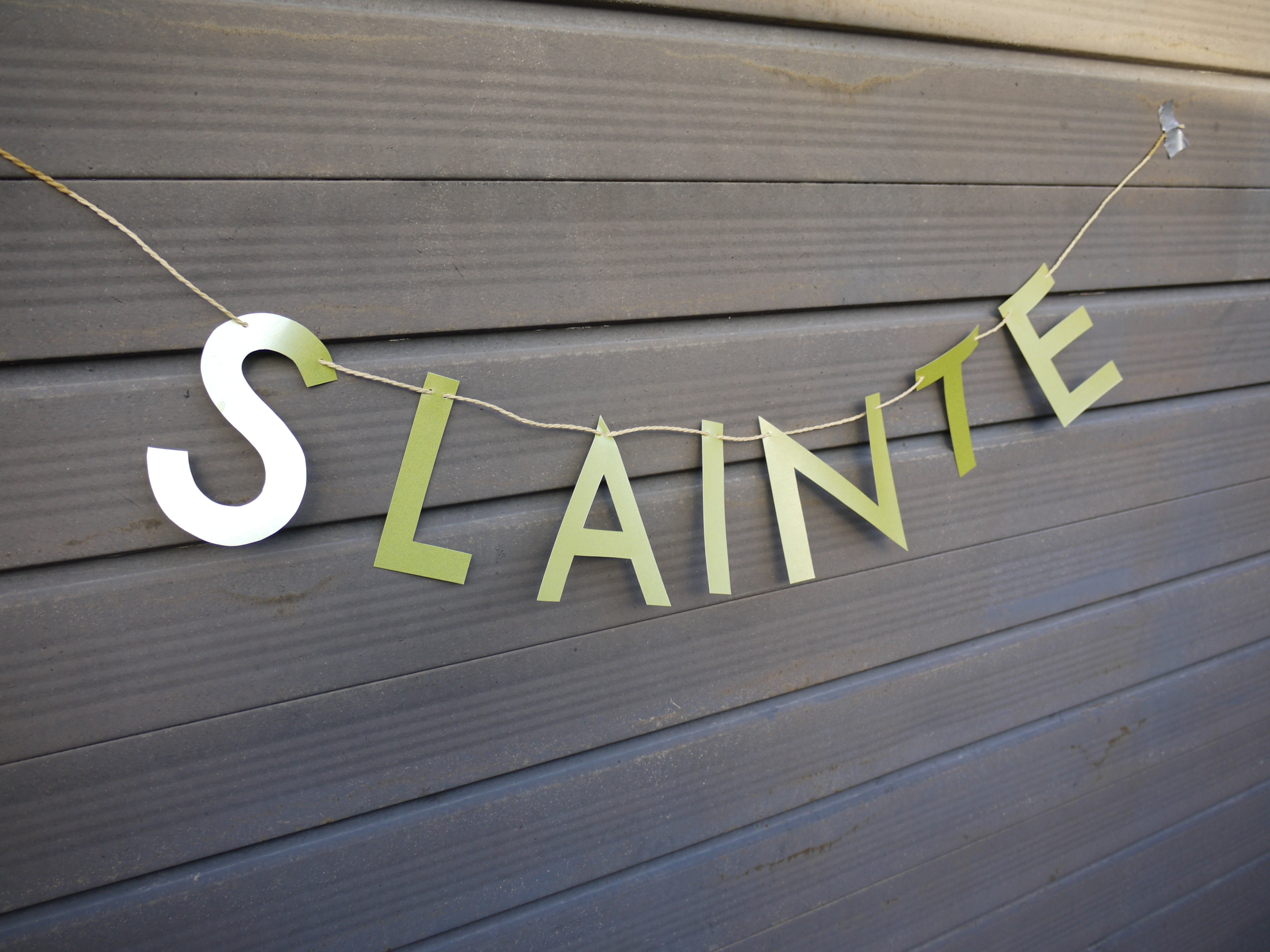 Green 'SLAINTE' banner on a grey surface