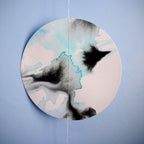 Close up of full moon shape wall paper garland painted with black and blue inks hung on on a blue wall