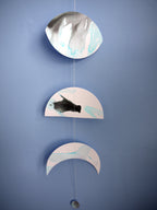 Moon phases wall hanging stitched paper garland painted with black and blue ink on a blue wall