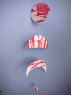 Close up on a pink and red moon phases paper garland with crescent and half moon shapes