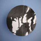 Circular black and white moon shape from a paper garland against a blue background