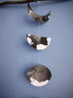 Decorative moon phases garland in black and white on a blue background