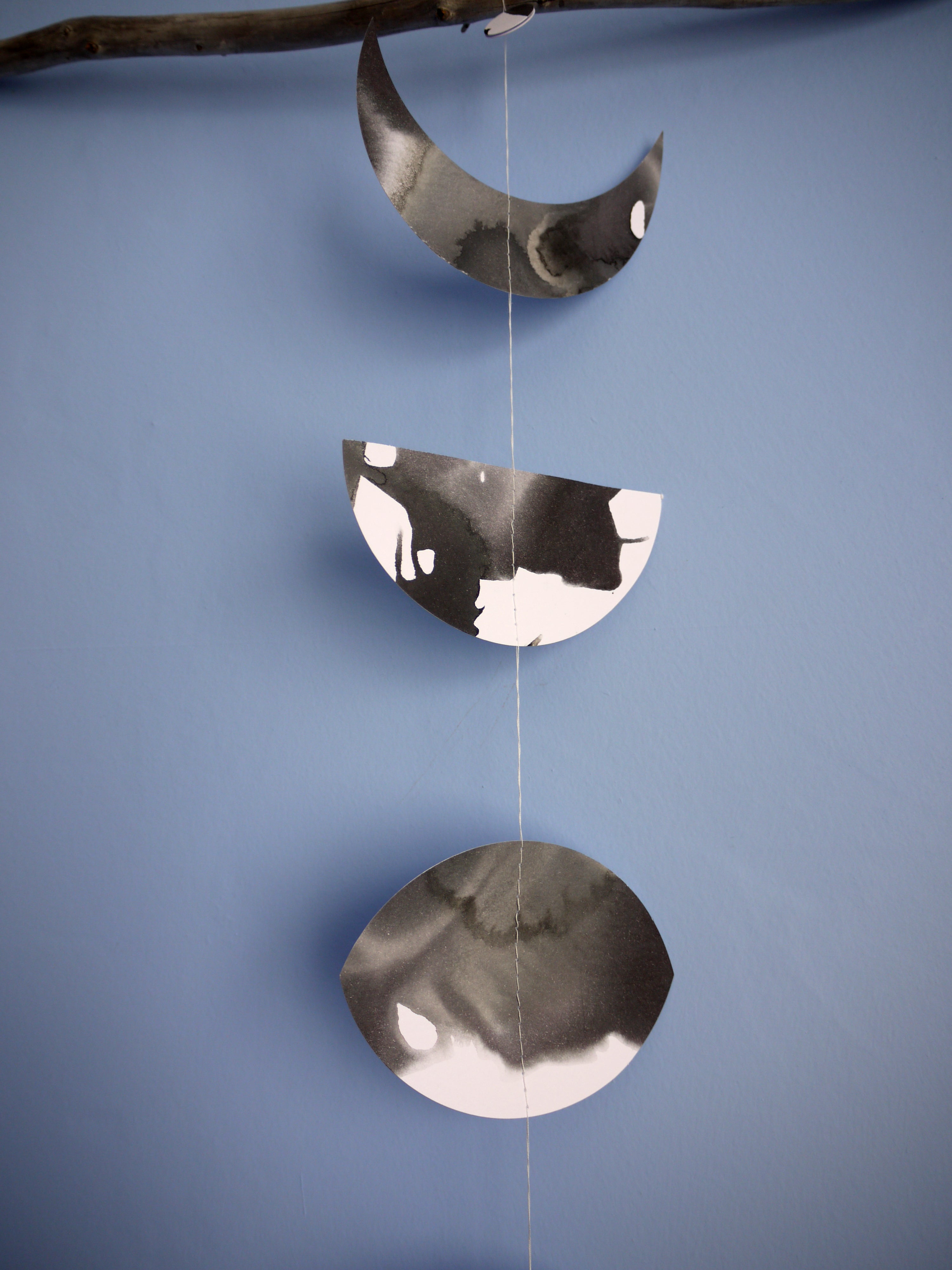 Decorative moon phases garland in black and white on a blue background