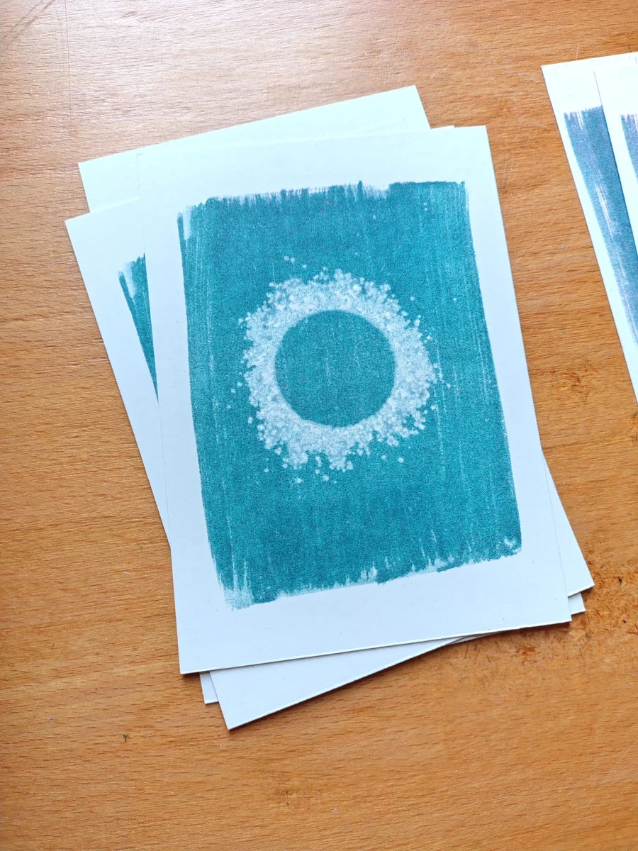 A stack of small blue art riso prints featuring a unique cyanotype of salt.
