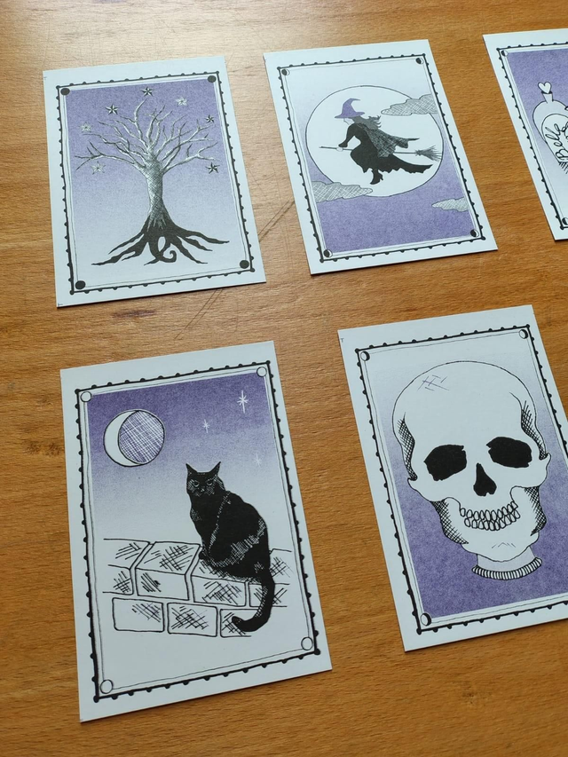 Set of halloween riso prints with mystical illustrations on a wooden surface