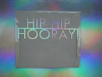 Holographic reusable birthday party cake topper that reads 'HIP HIP HOORAY!'. Perfect for every type of celebration.