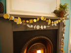 Geometric paper garlands. Silver and gold multi shape garlands draped across a fireplace mantel in a home setting for fun easy party themes