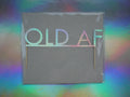 Holographic birthday cake topper with the phrase 'OLD AF' set against a holographic rainbow background.