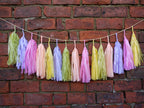 Pastel colourful tassel garland on a brick wall