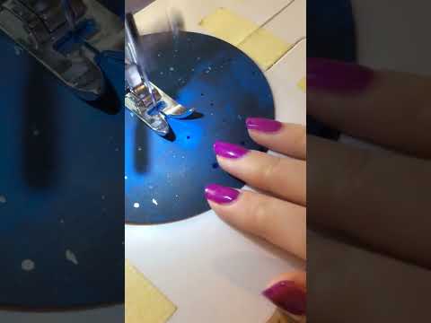 Process video showing a circular blue moon shape being sewn into a moon phases paper garland